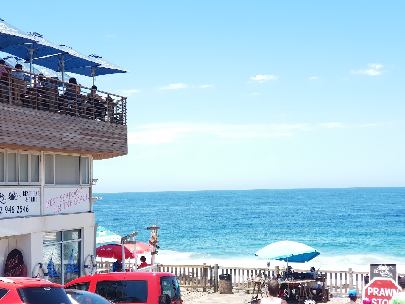 A group of people on a balcony overlooking the oceanDescription automatically generated